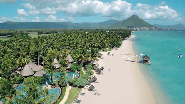 Ranta lähistöllä, aurinkotuoleja, rantapyyhkeitä