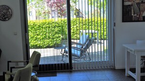 A room with a sliding glass door leading to an outdoor seating area with chairs and a table.