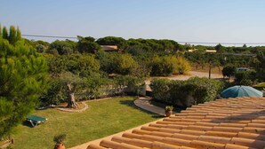 Zona residencial amb un jardí ben cuidat, un camí corbat i un teulat d'autelles.