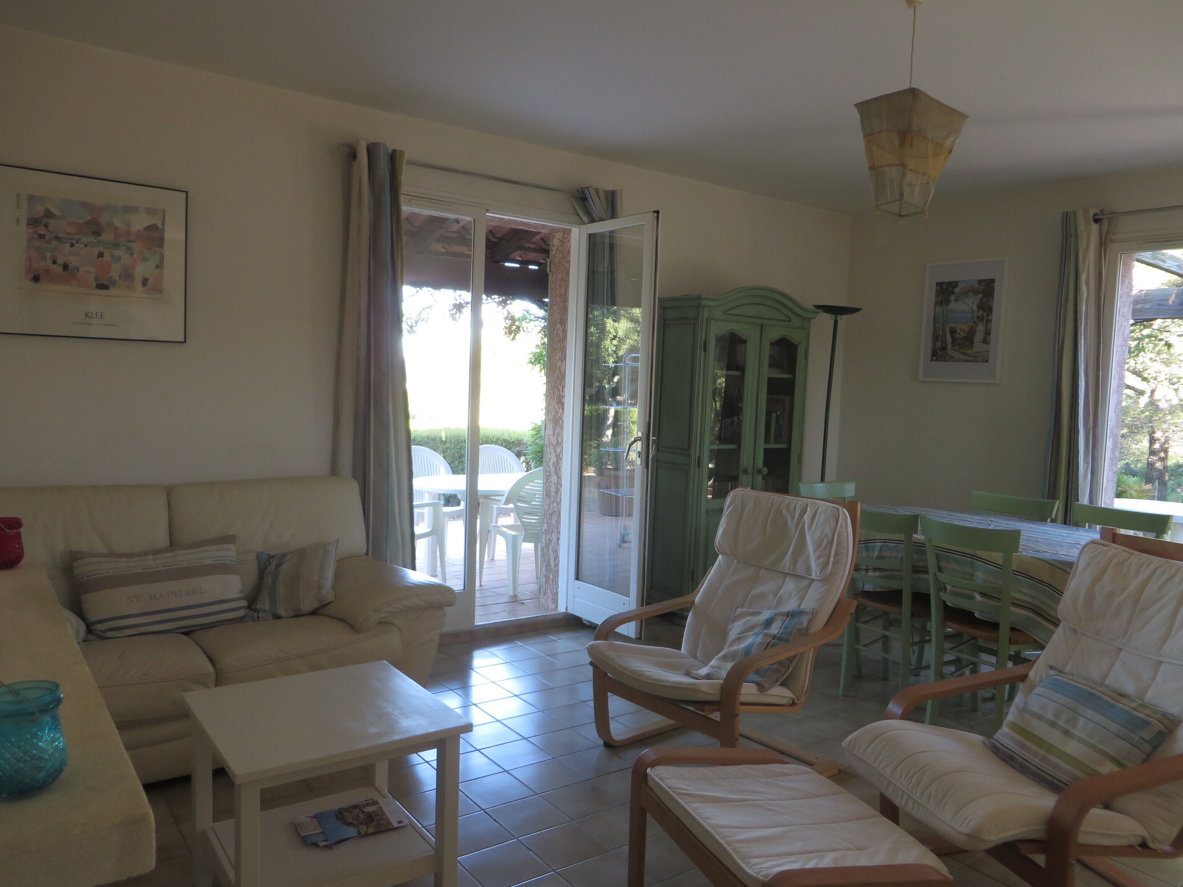 Un salon comprenant un canapé, des fauteuils, une table et un coin repas avec des chaises et une table.