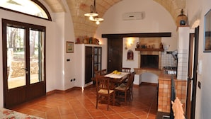 A spacious kitchen with a dining area, featuring a large table, chairs, and a built-in oven. - Typical Salento residence (Alessano)