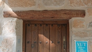 A wooden door with a rustic stone wall and a sign indicating a tourist use area.