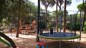 A playground with a trampoline, swings, and a small slide. - 100 meters from the sea Villa immersed in the greenery (Santa Margherita di Pula)