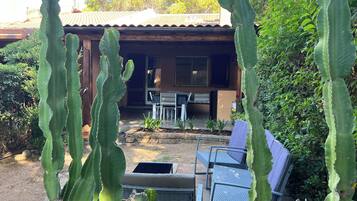 Una casa con un patio, circondata da grandi cactus.