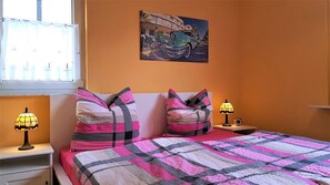 Cozy retreat with a vibrant wall, a geometric-patterned quilt, and a classic bedside lamp on each side.