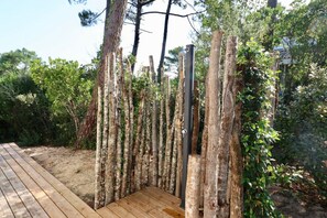 A wooden deck with a natural, rustic fence made of vertical wooden slats. - Exquisite villa with heated pool near beach A3697 (Lège-Cap-Ferret)