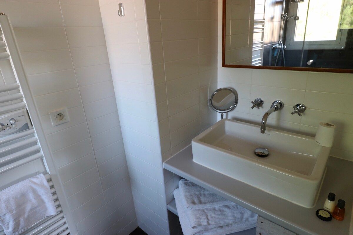 A bathroom with a white sink, a mirror, and a towel rack.