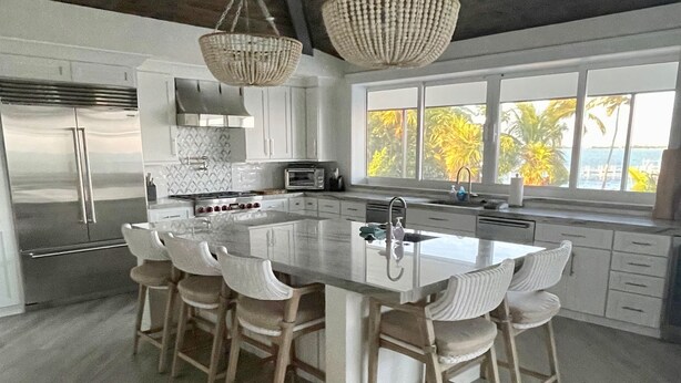 A modern kitchen with a large island, stainless steel appliances, and a view of the outdoors. - 5 bedrooms, Heated/Chilled  Pool, Open Water Views, Boat Dockage, Sleeps 13--15, (Marathon)