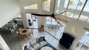 A spacious living area with a large sectional sofa, a round coffee table, and a view of the ocean through large windows. - 5 bedrooms, Heated/Chilled  Pool, Open Water Views, Boat Dockage, Sleeps 13--15, (Marathon)