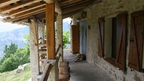 Un escalier en bois rustique mène à un balcon où un chien se repose sur le plancher.