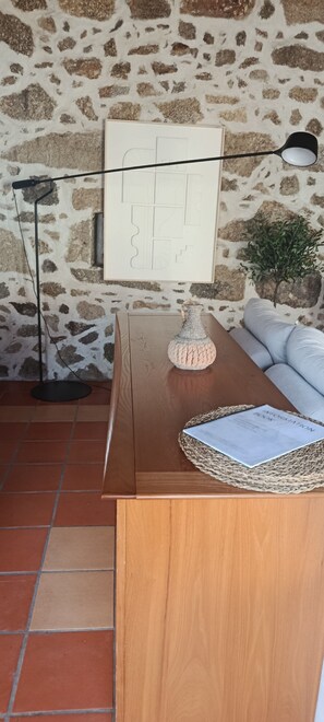 Un mostrador de recepción de madera con una lámpara, un jarrón decorativo y una planta.
