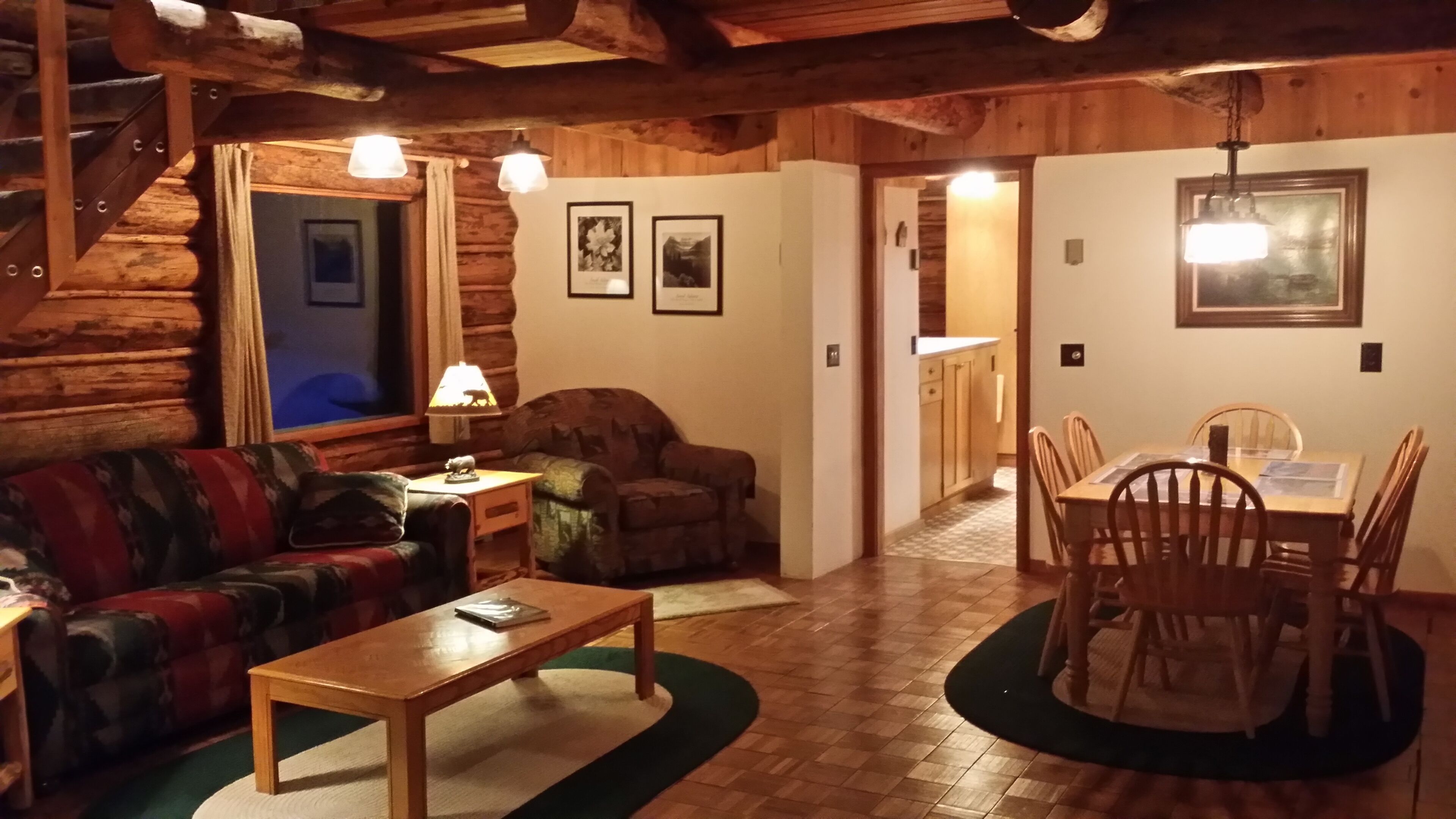 Un acogedor interior de cabaña de madera con sala de estar, comedor y cocina.
