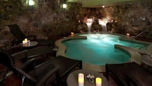 A spa area with a hot tub, stone walls, and seating.