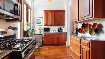 Une cuisine avec des meubles de rangement en bois, une cuisinière et un four à micro-ondes.