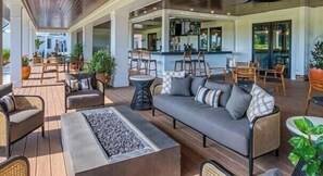 Un espace extérieur aménagé avec un canapé, des fauteuils et un foyer.
