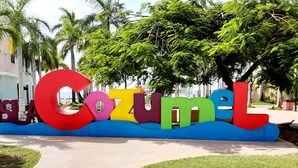 Un letrero colorido con el texto "ISLA COZUMEL" en letras grandes y llamativas.