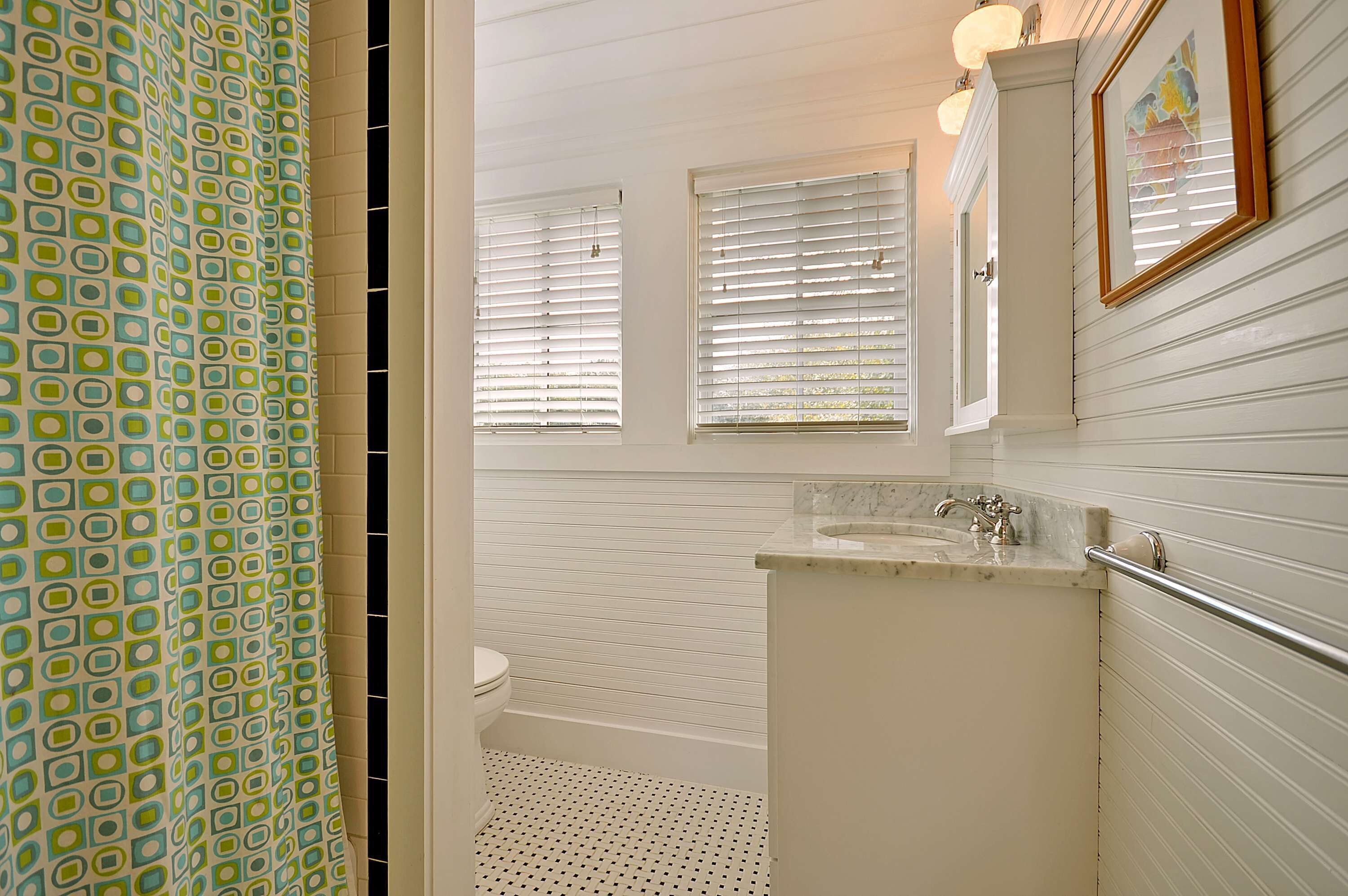 A bathroom with a toilet, a sink, and a window.