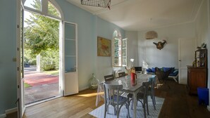 Un comedor con una mesa dispuesta para cuatro personas, un ventanal y vistas al exterior.