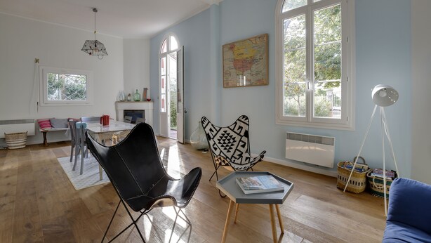 Un salón amplio con comedor, ventanas grandes y un mapa en la pared.
