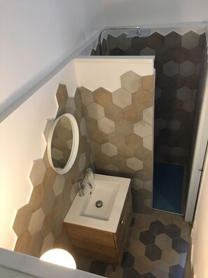Tina con regadera, secadora de cabello, bidet, papel de baño 