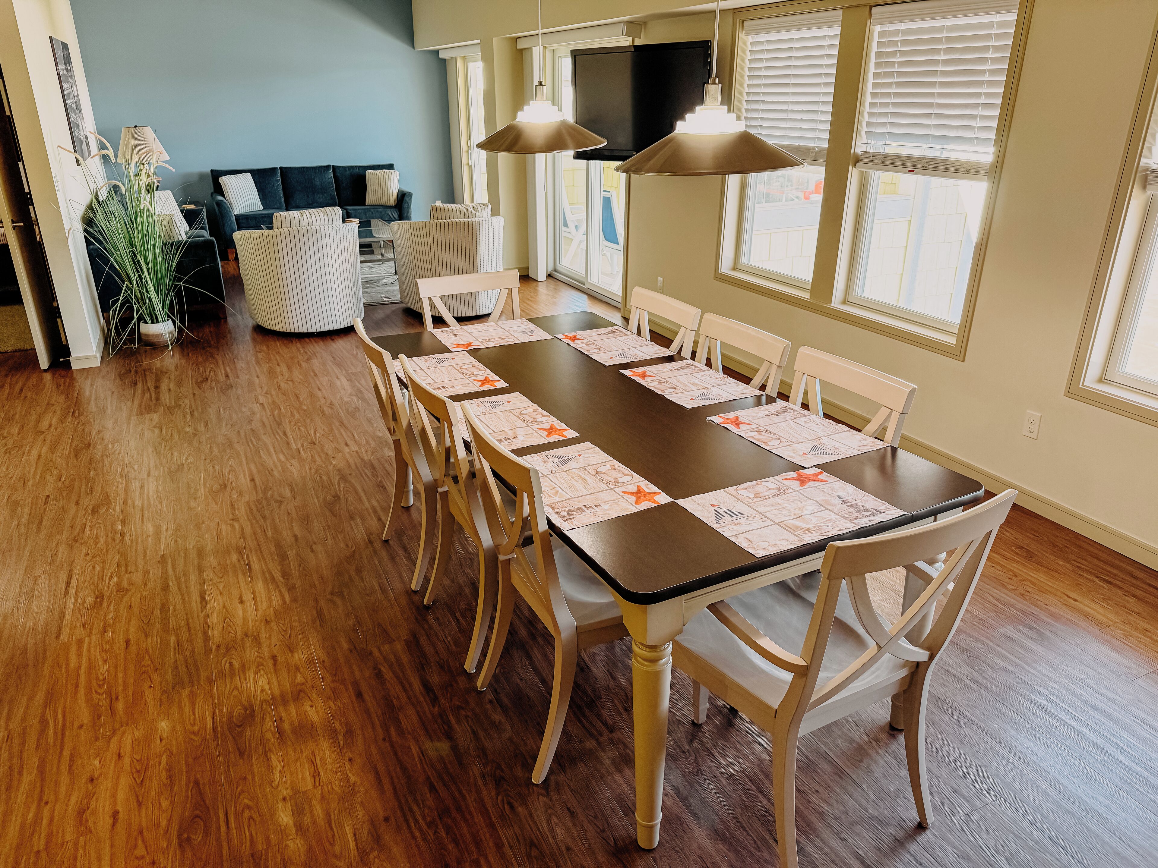 Een eetgedeelte met een lange tafel gedekt voor zes personen, omringd door houten stoelen.