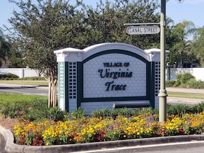 Een bordje voor de Village of Virginia Trace, met een bloembed voor ernaast.