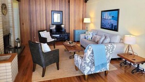 A cozy living room with a fireplace, a television, and a sofa. - On the beach!! Oceanfront luxury - Incredible Views and Private Beach Access (Blaine)