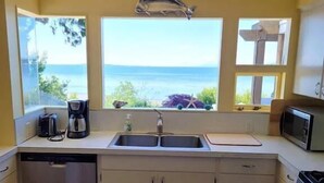 A kitchen with a view of the sea, a coffee maker, and a microwave. - On the beach!! Oceanfront luxury - Incredible Views and Private Beach Access (Blaine)