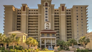 Een groot, meerhoog hotel met een centraal torentje, balkons en een fontein in de binnentuin.