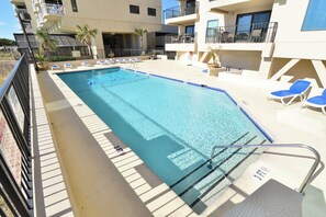 Une piscine équipée de chaises longues et d’un poste de surveillance pour les sauveteurs.