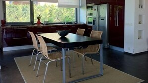 Una cocina moderna con una mesa de comedor, sillas y un refrigerador.