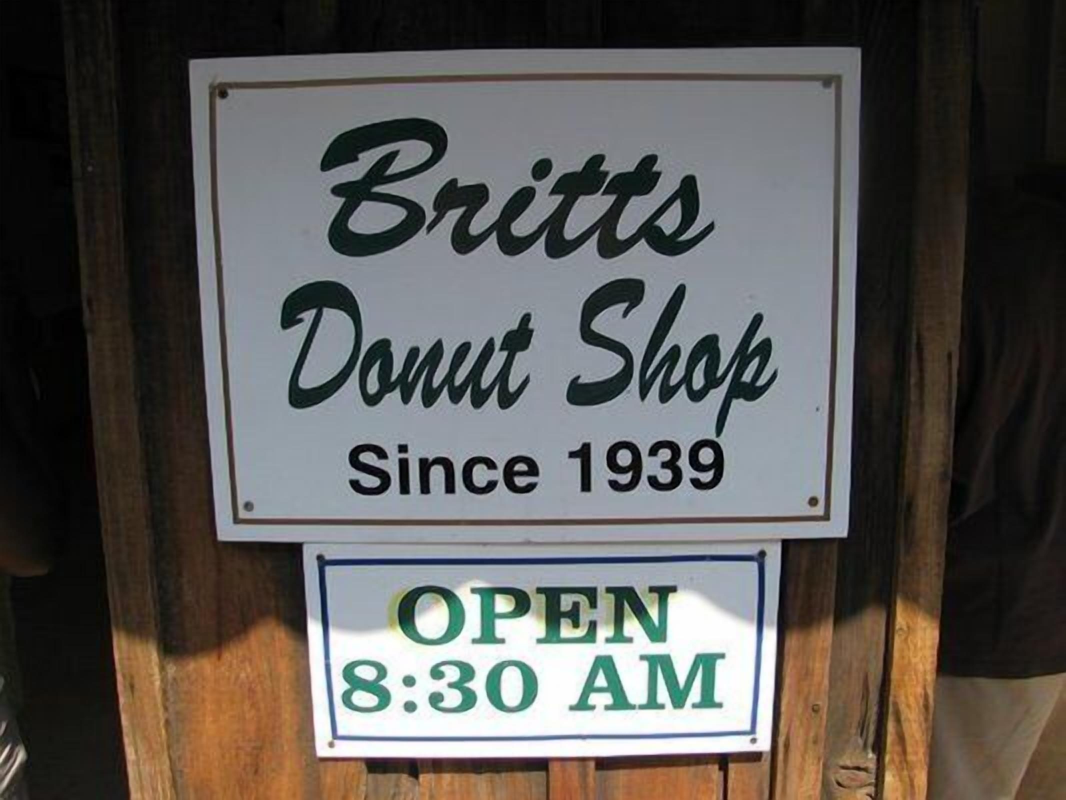 Une enseigne indiquant « Britt's Donut Shop », précisant que le magasin est en activité depuis 1939 et ouvre à 8h30.