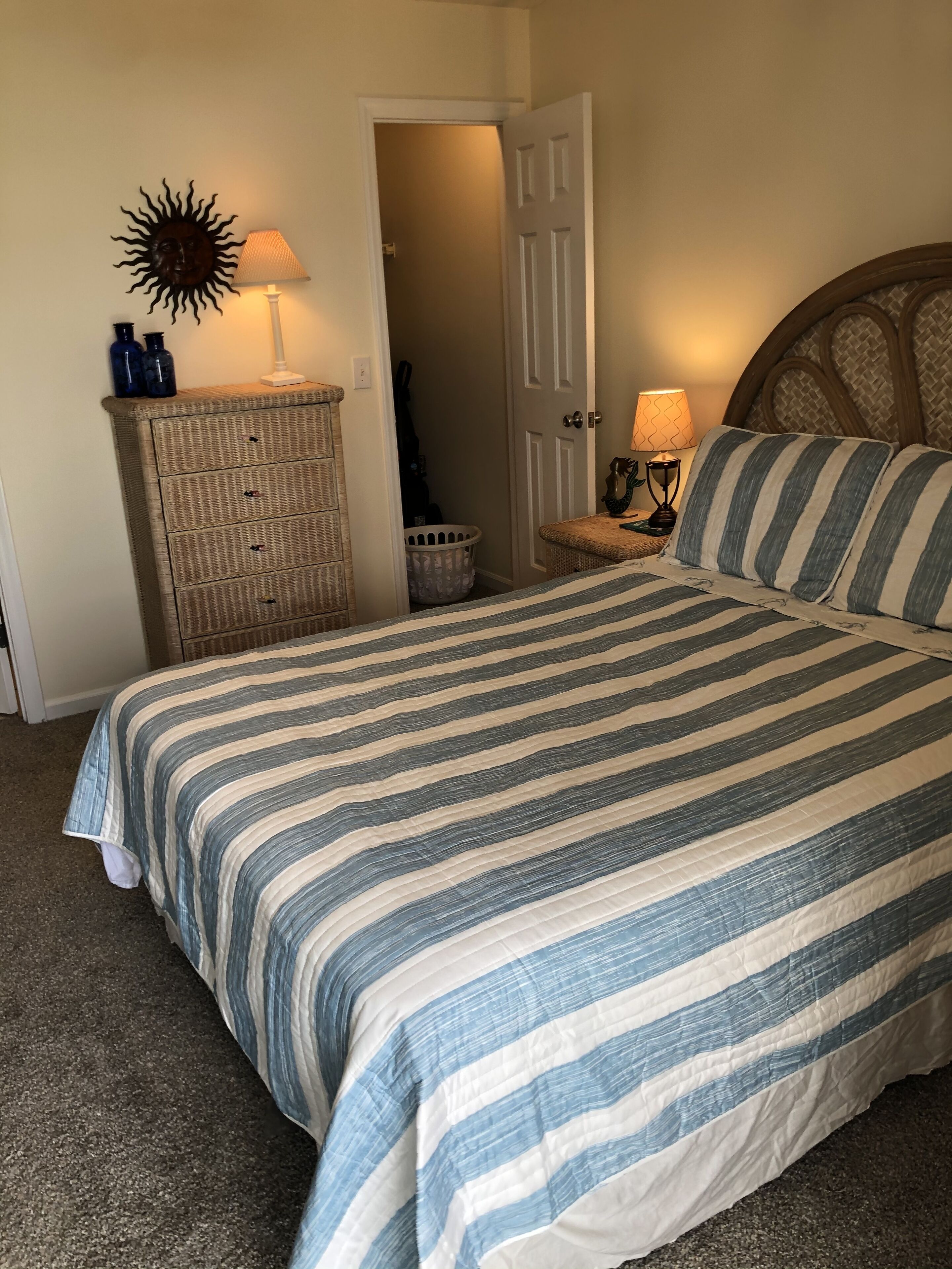 Een slaapkamer met een bed, een kaptafel, een lamp en een deur.