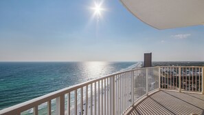 A balcony with a view of the ocean and a building in the distance. - Emerald Isle 1701 - BEACH CHAIRS INCLUDED! Affordable rates! (Panama City Beach)