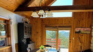 Ein Holzinnenraum mit Essbereich, Küche und einem großen Fenster.
