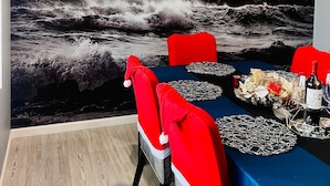A dining area with a large ocean mural, a blue tablecloth, red chairs, and a variety of tableware. - BEAUTIFUL HOME WITH HEATED POOL!!! (Venice)
