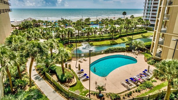 A resort with a swimming pool, lounge chairs, and a view of the beach and ocean. - Royale Palms 14022H Oceanview Studio in Kingston (Myrtle Beach)