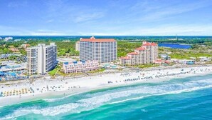 Ein Küstenhotel mit mehreren Gebäuden, einem Strand und Blick auf den Ozean.