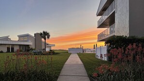 Un sendero que conduce a un edificio moderno con techo plano y balcón.