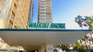 A hotel sign with the name "Waikiki Shore" and a notice board. - Beach Front Studio With Spectacular Ocean Views (Honolulu)