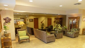 A spacious lobby with a high ceiling, tiled flooring, and a variety of seating options including sofas and armchairs. - Beach Front Studio With Spectacular Ocean Views (Honolulu)