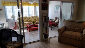 A living room with a sofa, armchairs, a coffee table, and a bookshelf. - Spectacular Beach House with community pool.
Minutes to beaches (Lewes)