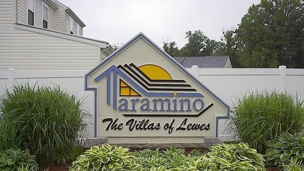 Schild für 'Taramino The Villas of Lewes' mit stilisierter Haus- und Sonnendarstellung.