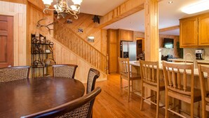 A wooden interior with a dining table, chairs, a staircase, and kitchen area. - Fabulous Cabin Block away from<br>Private Beach (Tahoe City)