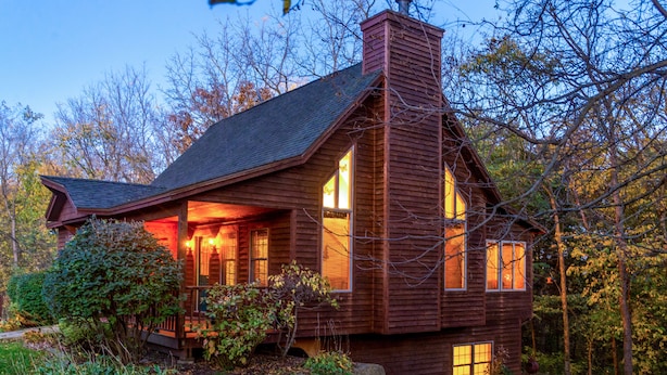 A rustic wooden cabin with a porch, surrounded by trees and a well-maintained garden. - Charming 3BR / 3BA With Hot Tub, Fireplace & Pool Table (Galena)