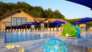 A swimming pool with water fountains, lounge chairs, and umbrellas. - Charming 3BR / 3BA With Hot Tub, Fireplace & Pool Table (Galena)