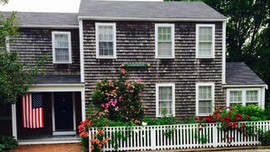 Une maison à deux étages avec un porche, un drapeau américain et une enseigne sur laquelle on peut lire « Evergreen ».