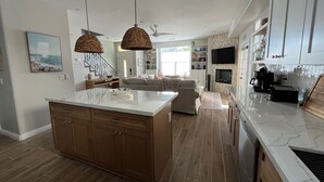 Una cocina amplia con una isla grande, armarios de madera y un diseño moderno.