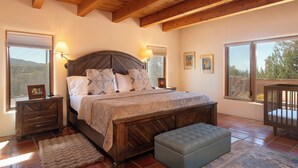 Un dormitorio con una cama de madera, dos lámparas de noche, una mesita de noche, una ventana y una cuna.