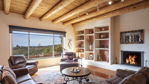 Amplia sala de estar con sofás de cuero, una mesa de centro y una chimenea.
